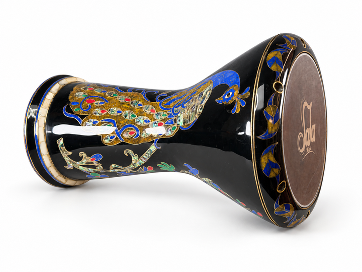 Sala Midnight Peacock Sombaty νταρμπούκα στο πλάι, που δείχνει την μεμβράνη του τυμπάνου με το σήμα Sala και ένα μπλε και χρυσό παγώνι με πολύχρωμες λεπτομέρειες ουράς σε σκούρο φινίρισμα.