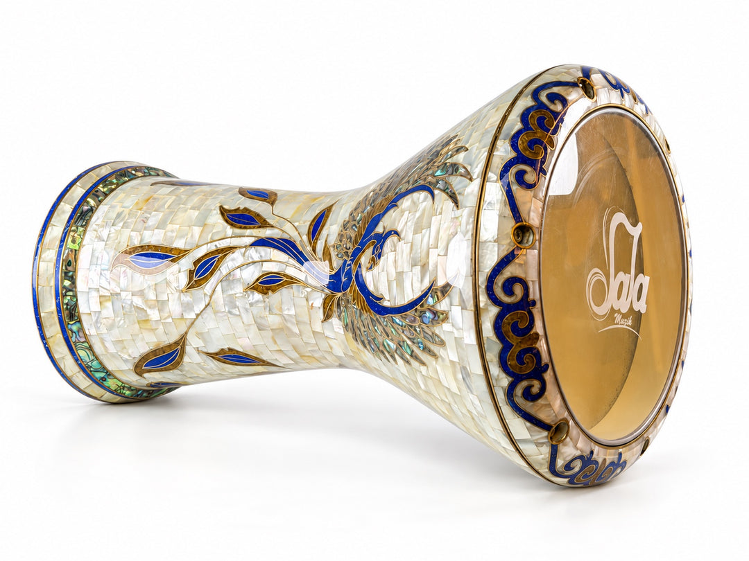Sala Phoenix Pearl Sombaty ダルブッカを横に置き、Sala ブランドのドラムヘッドと淡いモザイクに広がる青と金の鳥のモチーフを示しています。